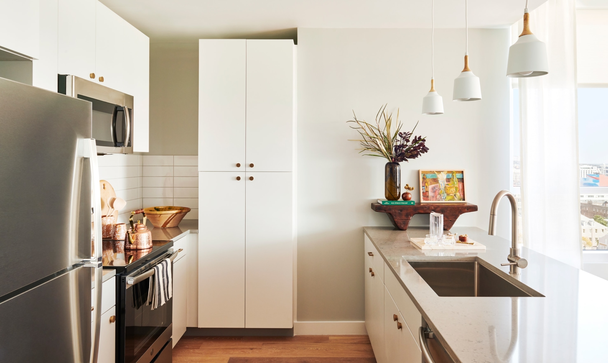 Inside the kitchen view of the large euro-style, white cabinets and pantry doors.