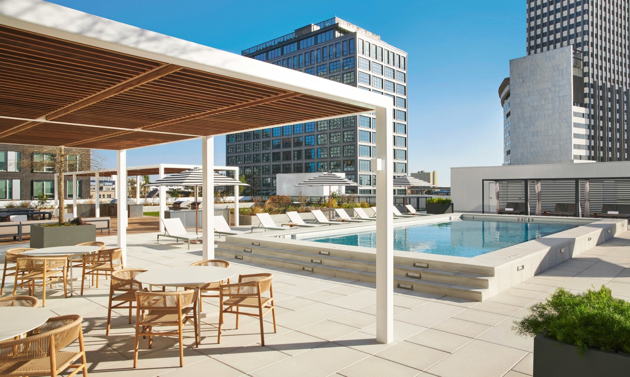 Rooftop pool deck with a resort-style pool, modern pool furniture and cabanas.