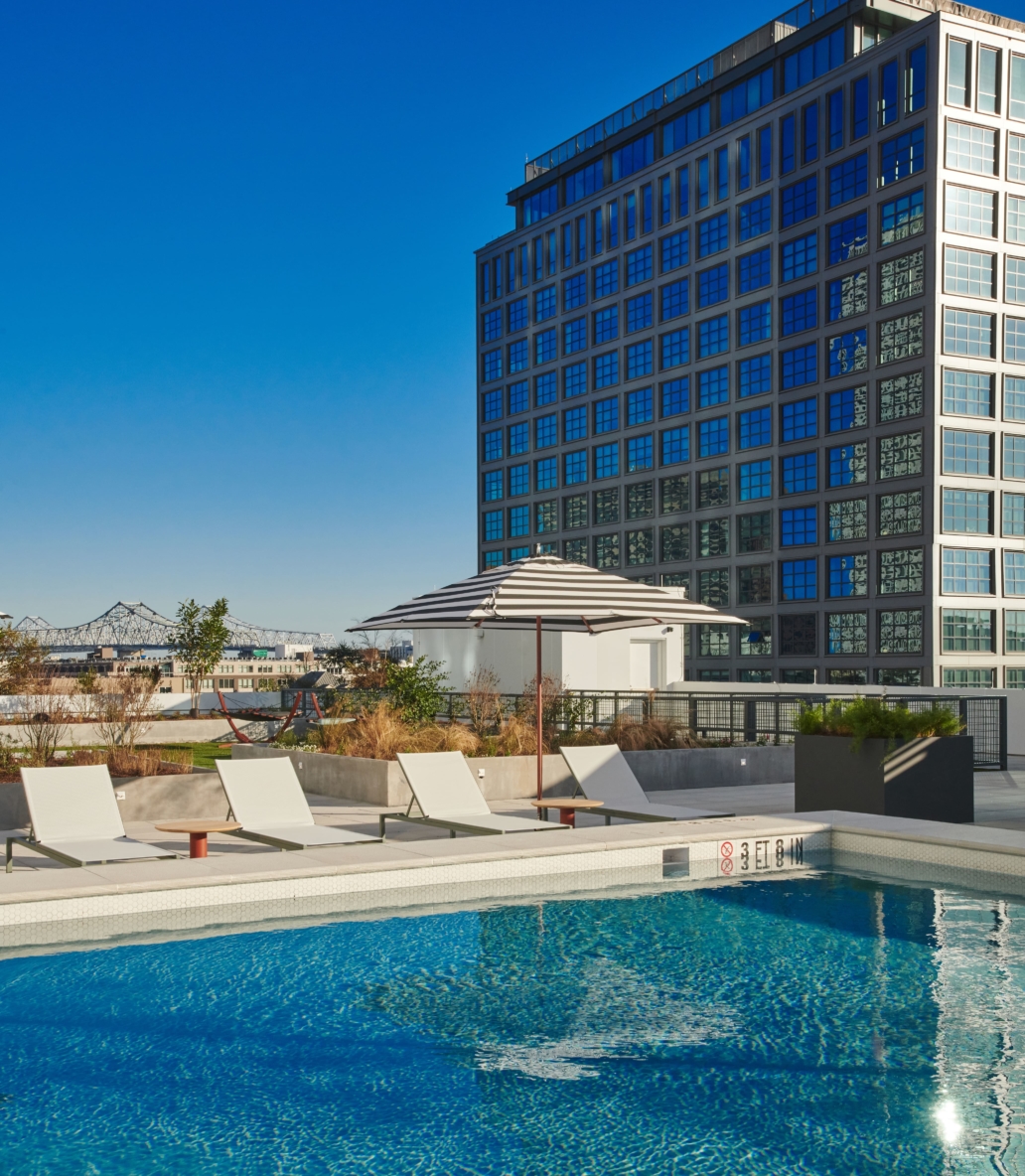 Roof-top swimming pool with resort lounge chairs and s360 degrees of skyline views.